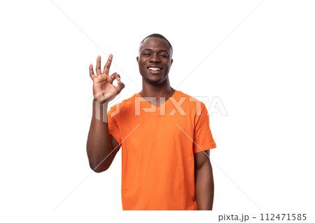 young slender American man dressed in an orange cotton t-shirt with a mockup. corporate color young slender American man dressed in an orange cotton t-shirt with a mockup. corporate color 112471585