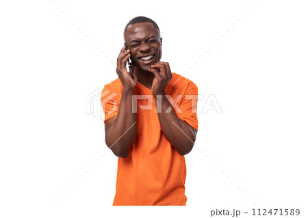 young energetic cheerful american man dressed in a basic orange t-shirt rejoices and smiles on a young energetic cheerful american man dressed in a basic orange t-shirt rejoices and smiles on a 112471589