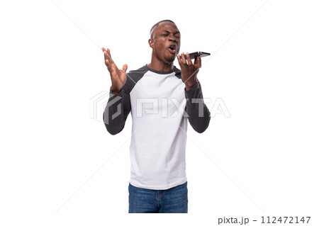a young well-groomed African guy dressed in a black-and-white sweatshirt and jeans speaks on the 112472147