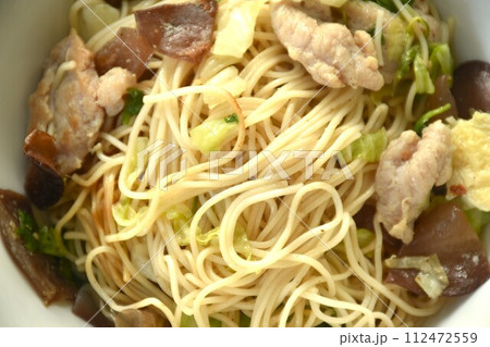 fried Chinese yellow rice noodles with cabbage and pork on bowl 112472559