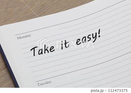 Take it easy reminder message in an open diary 112473375