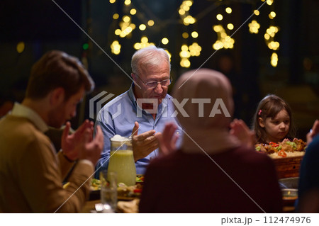 In a modern restaurant setting, a European Islamic family comes together for iftar during Ramadan, engaging in prayer before the meal, uniting tradition and contemporary practices in a celebration of In a modern restaurant setting, a European Islamic family comes together for iftar during Ramadan, engaging in prayer before the meal, uniting tradition and contemporary practices in a celebration of 112474976
