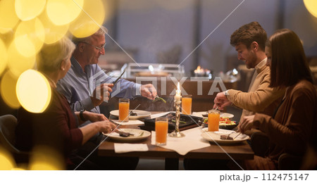 A modern and traditional European Islamic family comes together for iftar in a contemporary restaurant during the Ramadan fasting period, embodying cultural harmony and familial unity amidst a A modern and traditional European Islamic family comes together for iftar in a contemporary restaurant during the Ramadan fasting period, embodying cultural harmony and familial unity amidst a 112475147