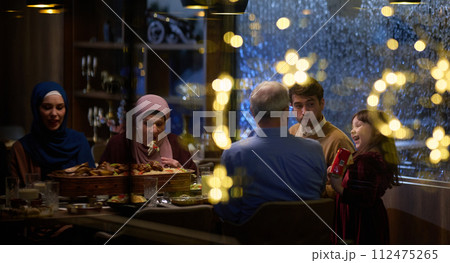 A modern and traditional European Islamic family comes together for iftar in a contemporary restaurant during the Ramadan fasting period, embodying cultural harmony and familial unity amidst a 112475265