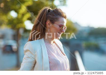 smiling elegant 40 years old woman in dress and jacket in city smiling elegant 40 years old woman in dress and jacket in city 112475895