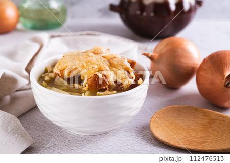 Homemade onion soup with croutons and cheese in a bowl on the table 112476513