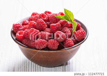 Raspberry in a basket .on wooden background Raspberry in a basket .on wooden background 112477721