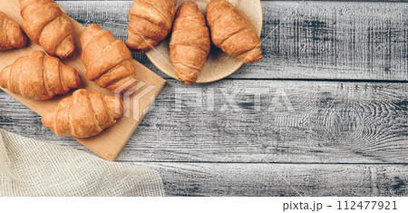 Freshly baked golden brown French croissants. Tasty baked croissants, warm buttery croissants, breakfast concept 112477921