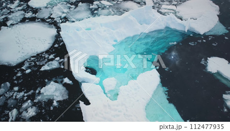 Melting iceberg underwater ice in Antarctica. Crashed glacier pieces floating icy cold ocean. Arctic scene. Ecology, melting ice, climate change and global warming concept. Aerial top view drone shot Melting iceberg underwater ice in Antarctica. Crashed glacier pieces floating icy cold ocean. Arctic scene. Ecology, melting ice, climate change and global warming concept. Aerial top view drone shot 112477935