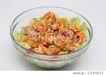 Fresh shrimp salad made of tomato. Caesar salad in a transparent bowl on wooden background. Seafood. Fresh shrimp salad made of tomato. Caesar salad in a transparent bowl on wooden background. Seafood. 112478115