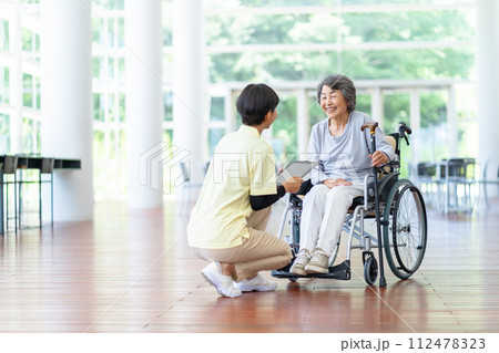 介護士とお婆さん　車いすに座ったシニア女性 112478323