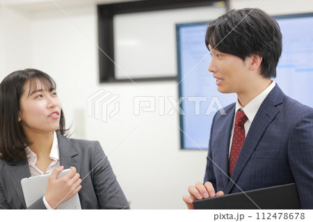 立って打ち合わせ_相手をバカにしたように話すビジネスマン_1 立って打ち合わせ_相手をバカにしたように話すビジネスマン_1 112478678