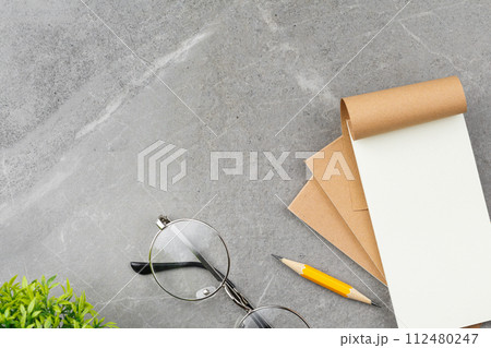Open notepad on gray marble background. 112480247