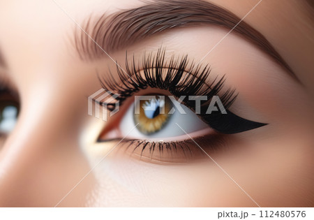 Creative makeup with extended eyelashes and eyeliner arrows. The concept of stylish makeup, close-up 112480576