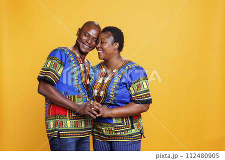 Happy smiling man and woman romantic pair holding hands and standing together with closed eyes. Wife and husband showcasing love, hugging and posing with affection feeling 112480905