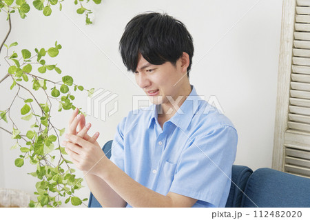 手が痺れる若い男性 112482020