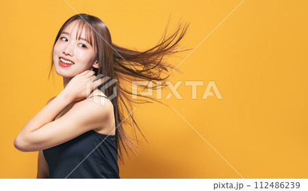 髪を風になびかせる女性のヘアケアやコスメやスキンケアのイメージ 112486239
