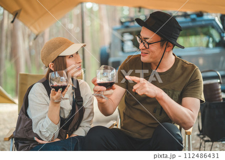 キャンプ場でワインを飲む夫婦・カップルキャンパー キャンプ場でワインを飲む夫婦・カップルキャンパー 112486431