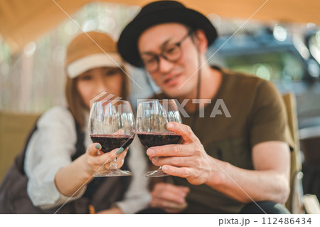 キャンプ場でワインを飲む夫婦・カップルキャンパー 112486434
