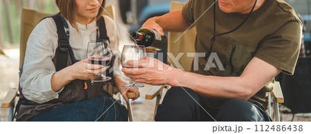 キャンプ場でワインを飲む夫婦・カップルキャンパー 112486438