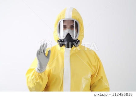 A person in a yellow hazmat suit and gas mask in white background .generative ai 112486819