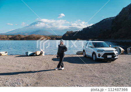 Woman tourist enjoy with Fuji Mountain at Lake Shoji, happy Traveler sightseeing Mount Fuji and road trip Fuji Five Lakes. Landmark for tourists attraction. Japan Travel, Destination and Vacation 112487366