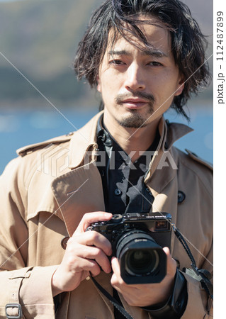 湖で写真を撮る30代男性 112487899