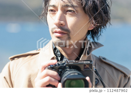 湖で写真を撮る30代男性 112487902