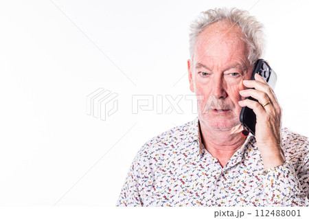 Senior Man in Thoughtful Conversation Over the Phone 112488001