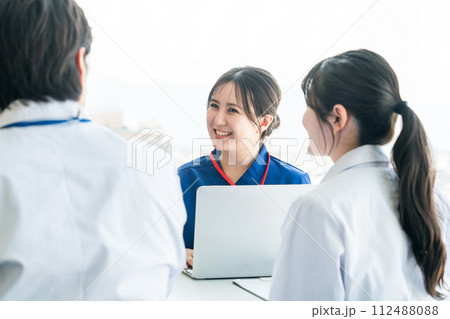 医局でカンファレンス・打ち合わせ・ミーティングする男女の看護師・技師・作業療法士・理学療法士・医師 112488088