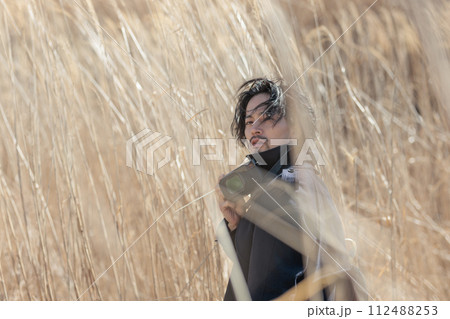 ススキの前でカメラを持つ30代男性 ススキの前でカメラを持つ30代男性 112488253