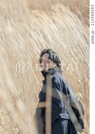 ススキの前でカメラを持つ30代男性 112488263