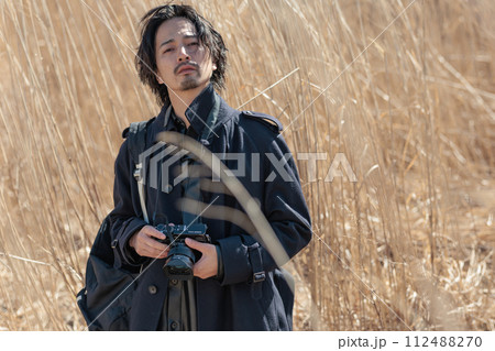 ススキの前でカメラを持つ30代男性 ススキの前でカメラを持つ30代男性 112488270
