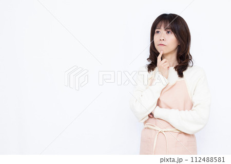 真剣に考えているエプロン姿の主婦 真剣に考えているエプロン姿の主婦 112488581