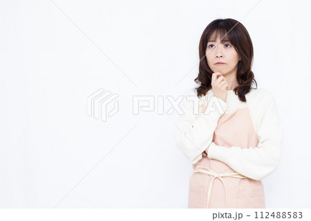 真剣に考えているエプロン姿の主婦 真剣に考えているエプロン姿の主婦 112488583