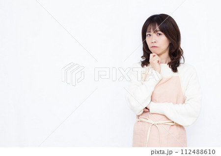 真剣に考えているエプロン姿の女性 112488610