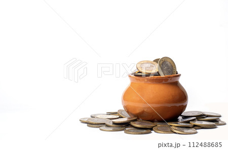 Coins in a clay pot on a white background with copy space. business and finance concept 112488685