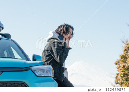 ドライブ中にトラブルに遭い電話をかける30代男性 112489875