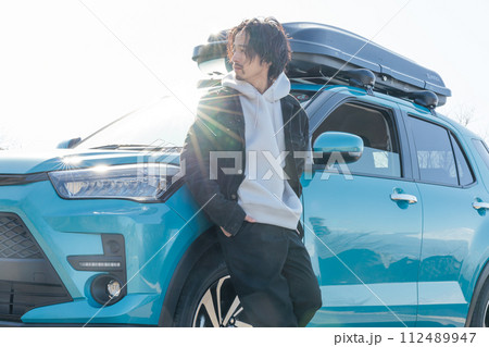 ドライブ中に駐車場で愛車と記念写真を撮る30代男性 112489947
