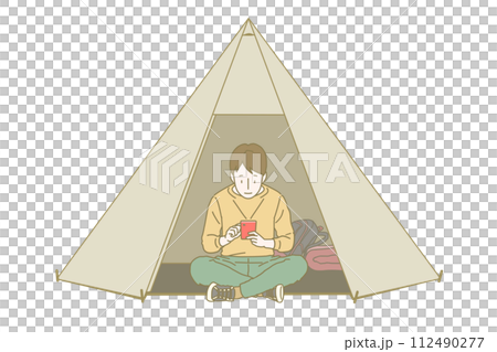 一個穿著長袖長褲的男孩盤腿坐在帳篷門口,放鬆地看著紅色的智慧型手機螢幕。 一個穿著長袖長褲的男孩盤腿坐在帳篷門口,放鬆地看著紅色的智慧型手機螢幕。 112490277