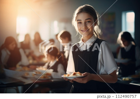 A schoolchild in the school cafeteria. Time of lunch break, peculiarities of the school meal, snack A schoolchild in the school cafeteria. Time of lunch break, peculiarities of the school meal, snack 112490757