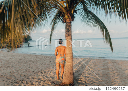 Woman walking on the beach in the morning Woman walking on the beach in the morning 112490987