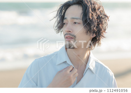 海辺に佇む白シャツを着た30代男性 112491056