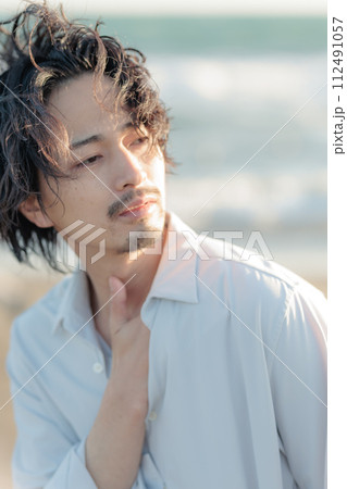 海辺に佇む白シャツを着た30代男性 海辺に佇む白シャツを着た30代男性 112491057