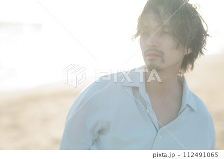海辺に佇む白シャツを着た30代男性 112491065