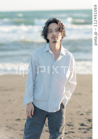 海辺に佇む白シャツを着た30代男性 112491069