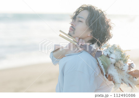 海辺に佇む白シャツを着た30代男性 海辺に佇む白シャツを着た30代男性 112491086