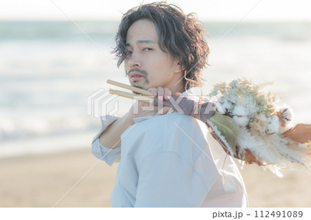 海辺に佇む白シャツを着た30代男性 海辺に佇む白シャツを着た30代男性 112491089