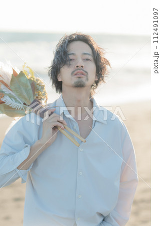海辺に佇む白シャツを着た30代男性 112491097