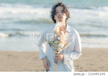 海辺に佇む白シャツを着た30代男性 海辺に佇む白シャツを着た30代男性 112491105